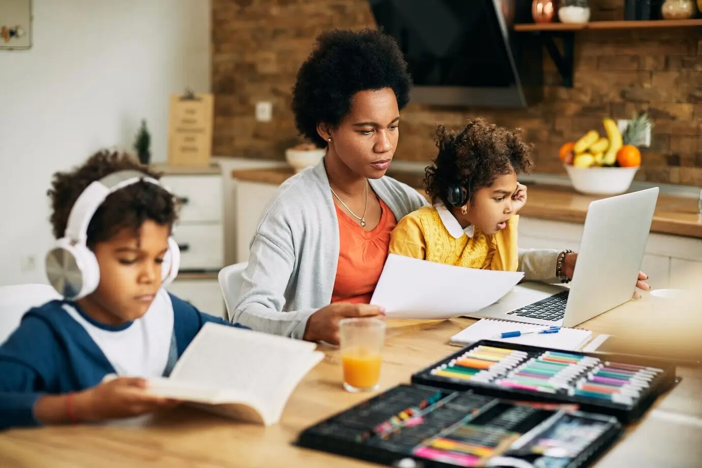 Berufstätige afroamerikanische Mutter mit Sohn und Tochter zu Hause